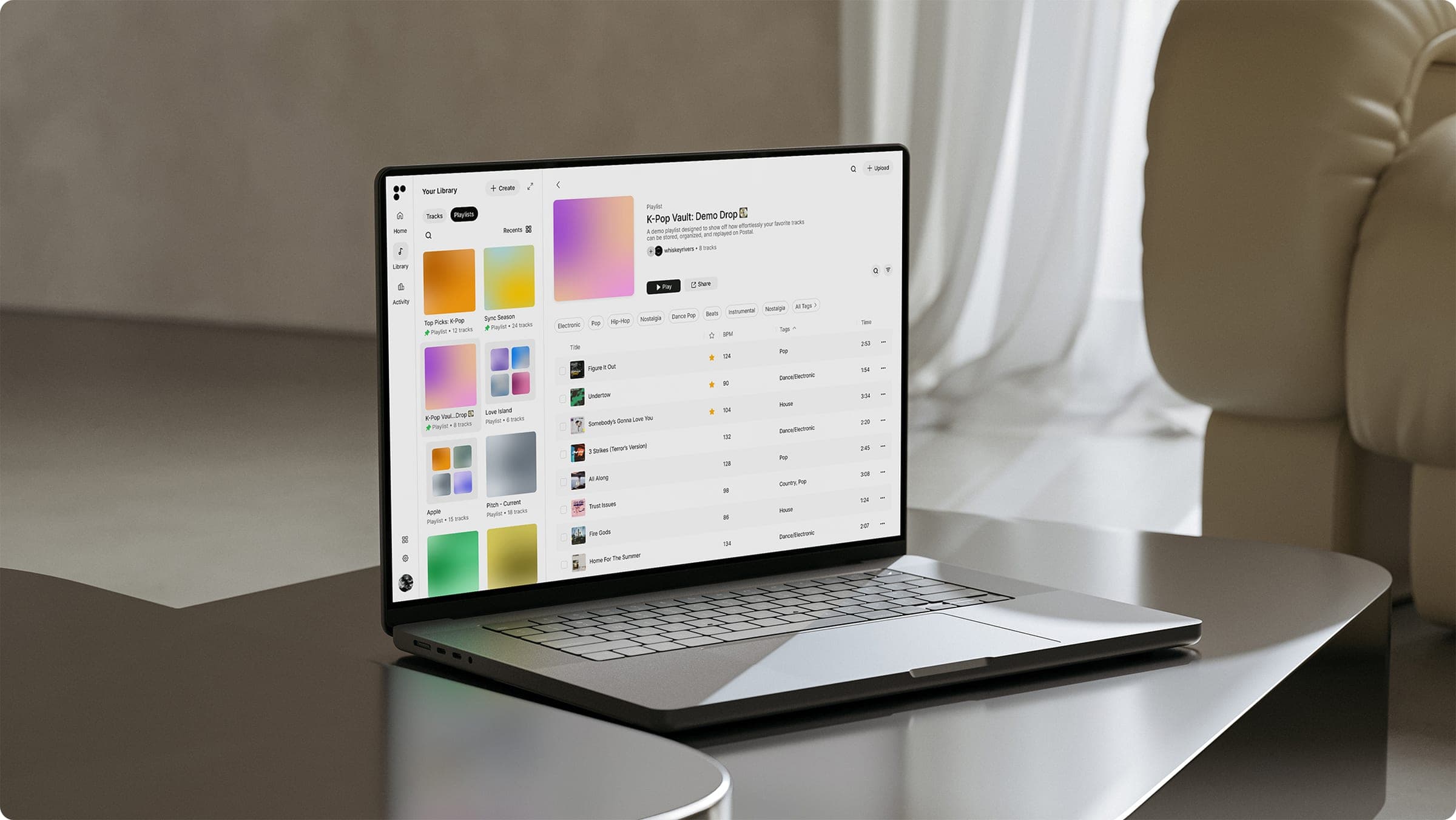 Producer organizing audio files, stems, and demos on a laptop